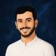 איור של גבר עם שיער כהה קצר, זקן ועגיל, מחייך ולובש חולצה לבנה, על רקע שמי לילה זרועי כוכבים.